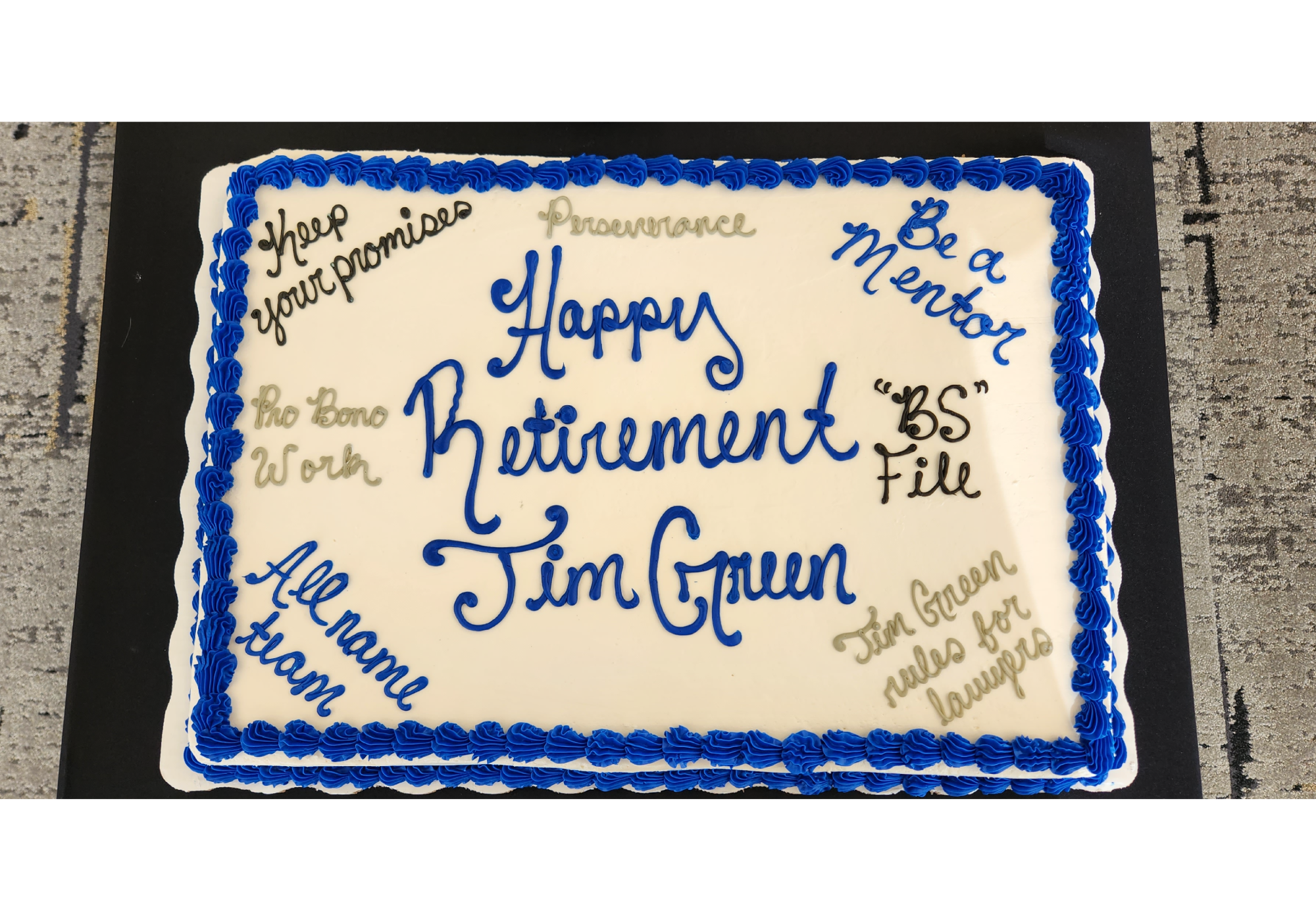 White cake with blue icing for Jim Green's retirement, quotes written on cake