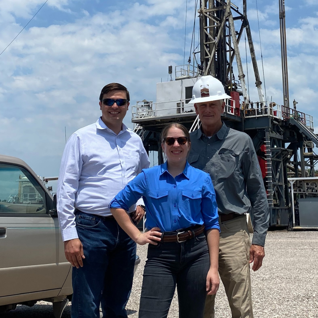 Three conner & winters attorneys in plain clothes in front of oil rig in southern Oklahoma